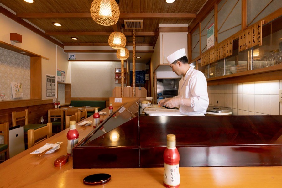 カウンターのある和食店の店内で働く料理人